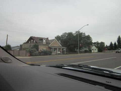 1991 Ford LTD Crown Victoria - View from a car's dashboard shows houses and a distant SUV on a cloudy day.