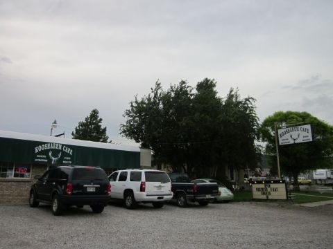 1991 Ford LTD Crown Victoria - Vehicles are parked in the lot of the Koosarem Cafe under an overcast sky.