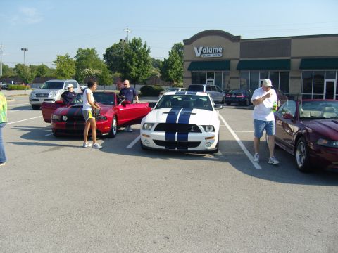 2007 Ford Mustang - Several Ford Mustangs are gathered in a parking lot outside a salon and spa.