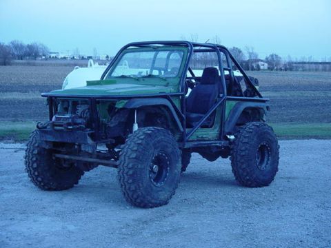 1992 Ford Bronco - This heavily modified off-road vehicle features a prominent roll cage and oversized tires, suggesting it is built for terrain.
