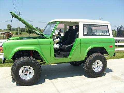 2007 Ford Mustang - A modified 1977 Ford Bronco with a bright green exterior and white roof is displayed outdoors.