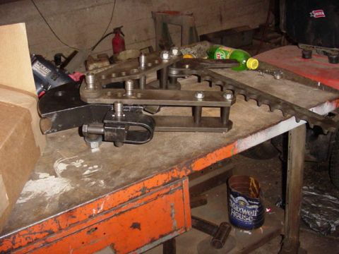 1992 Ford Bronco - A metal bending tool is shown on a workbench, accompanied by various items.