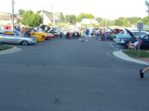 2007 Ford Mustang - A gathering of vehicles and people at an outdoor event, with a sign indicating parking restrictions.