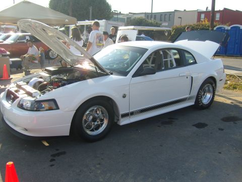 2007 Ford Mustang - A modified white Ford Mustang is displayed with its hood and trunk open at an outdoor event.