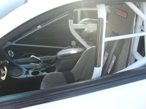 2007 Ford Mustang - Race car interior features a roll cage and racing seat with G-Force harnesses.
