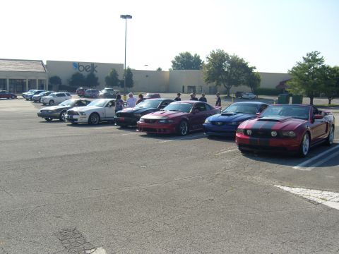 2007 Ford Mustang - Several Ford Mustangs are gathered in a parking lot in front of a Belk department store.