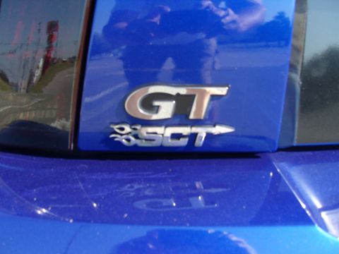 2007 Ford Mustang - Close-up of a GT SCT badge on a blue vehicle.