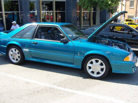 2007 Ford Mustang - A teal 1987 Ford Mustang coupe is displayed with its hood open, parked next to other vehicles.