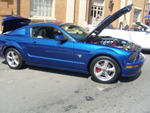 2007 Ford Mustang - A blue Ford Mustang is displayed with its hood and trunk open at an outdoor event.