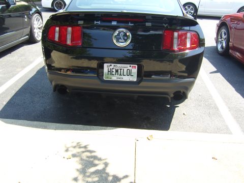 2007 Ford Mustang - Rear view of a black 2007 Ford Mustang GT parked next to other vehicles.