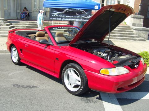 2007 Ford Mustang - A red convertible Mustang from 1994 is displayed with its hood open, revealing the engine bay.