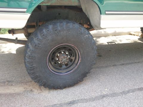 2004 Ford F-350 - Side view of a truck's rear tire and suspension components, including leaf springs.