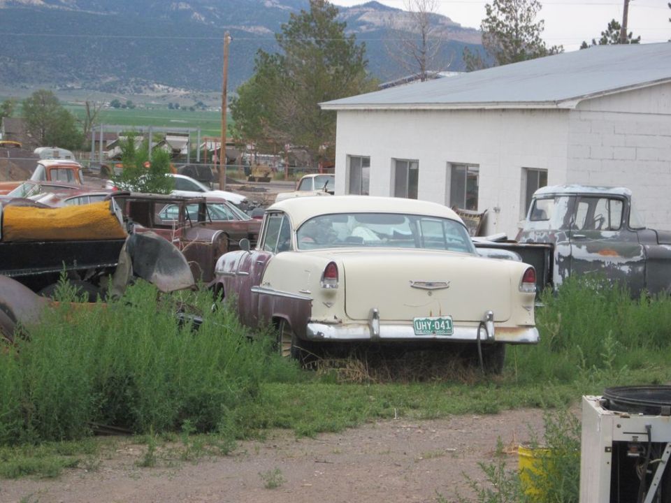 1955 Chevrolet Bel Air rear view, cream and maroon two-tone paint, UHY-041 license plate. Other vehicles and buildings in background