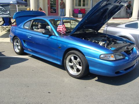 2007 Ford Mustang - A blue Ford Mustang is displayed with its hood open at an outdoor event.