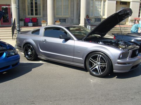 2007 Ford Mustang - A silver Ford Mustang GT is parked with its hood open, revealing the engine bay.