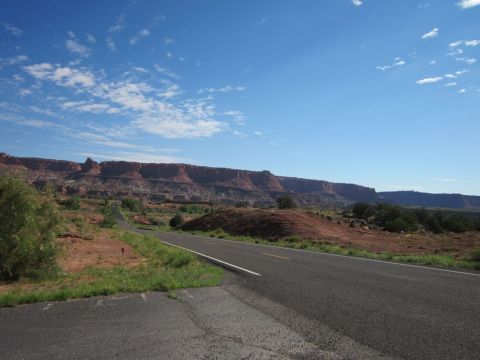 1991 Ford LTD Crown Victoria - A scenic view of a desert highway winding through red rock country under a bright blue sky.