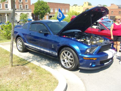 2007 Ford Mustang - A blue Ford Mustang GT 500 is displayed with its hood open at an outdoor car show.