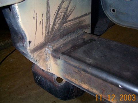 1986 Ford Bronco - Welded metal frame part with visible grinder marks and a watermark from Supermotors.net.