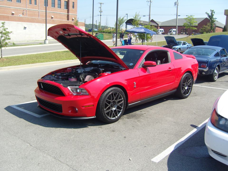Red 2007 Ford Mustang with hood open, parked in a lot