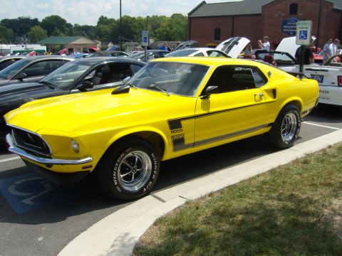 2007 Ford Mustang - A bright yellow 1969 Ford Mustang Boss 302 is parked at a car show.