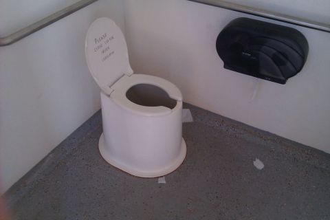 1991 Ford LTD Crown Victoria - Portable toilet with a note on the lid asking users to close it for privacy.