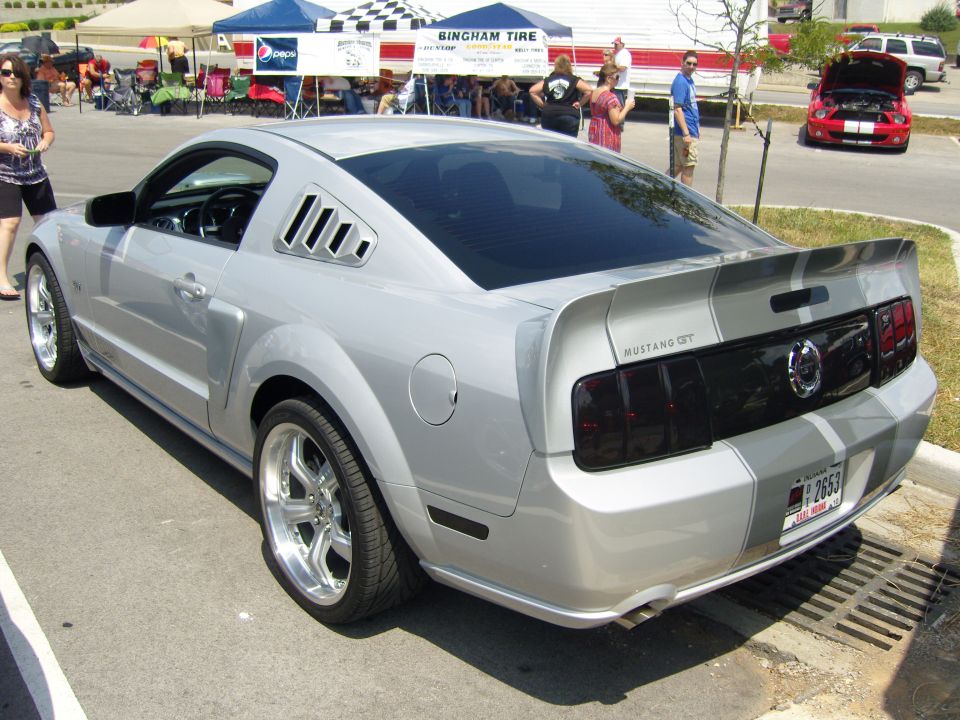 Silver 2007 Ford Mustang GT rear view with racing stripes and custom wheels