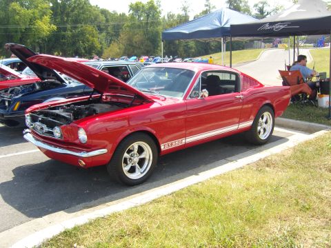2007 Ford Mustang - A red 1965 Ford Mustang GT350 is displayed at a car show with its hood up.