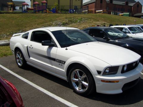 2007 Ford Mustang - A white Ford Mustang GT/CS is parked in a lot next to other vehicles.