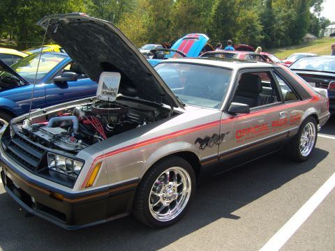 2007 Ford Mustang - A classic Ford Mustang from the 1980s is displayed with its hood up at a car event.