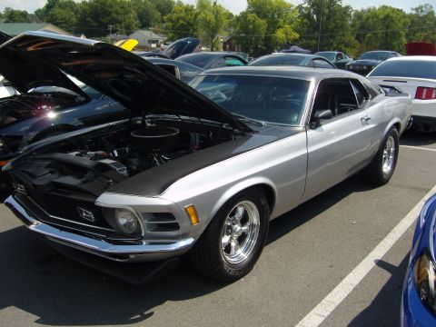 2007 Ford Mustang - A classic silver Ford Mustang from the 1970 model year is displayed with its hood open at a car show.
