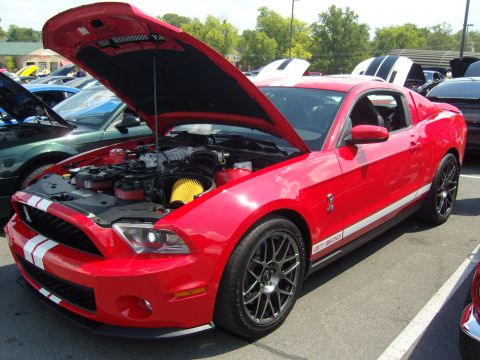 2007 Ford Mustang - A red Ford Mustang GT500 is displayed with its hood open, revealing the engine and air intake system.