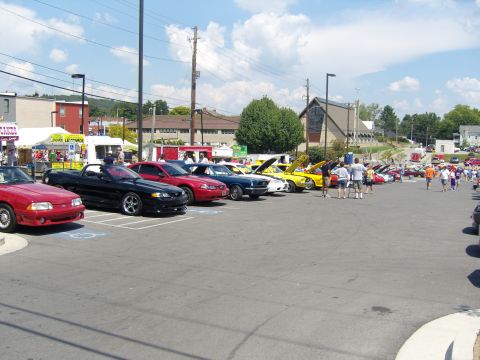 2007 Ford Mustang - Outdoor car show with many vehicles and attendees gathered on a sunny day.