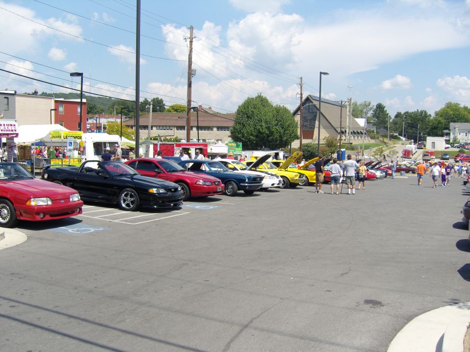 Parking lot filled with cars and people at an outdoor event