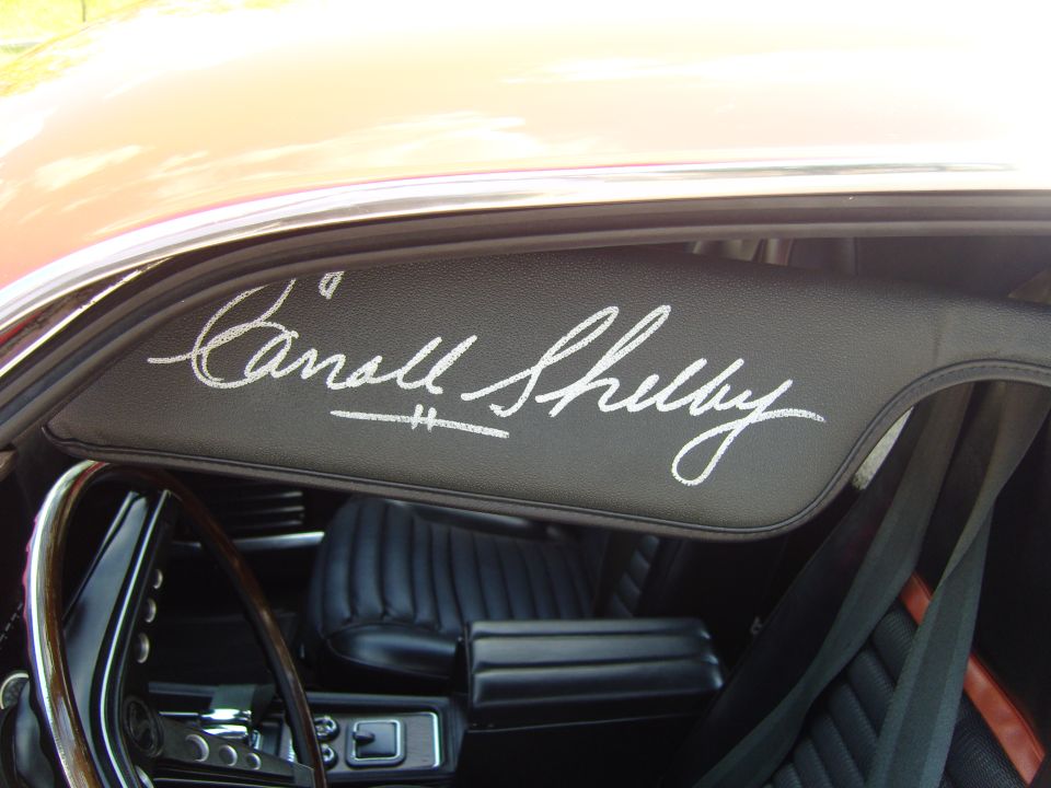 Carroll Shelby signature on black sun visor inside a car