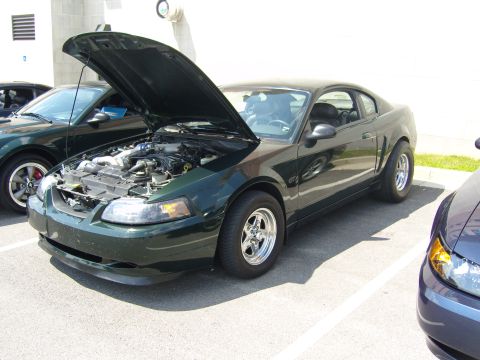 2007 Ford Mustang - A dark green Ford Mustang is parked with its hood open, revealing the engine compartment.