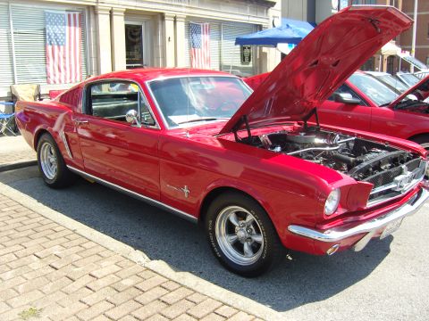 2007 Ford Mustang - A red 1965 Ford Mustang coupe is displayed with its hood open at a car show.