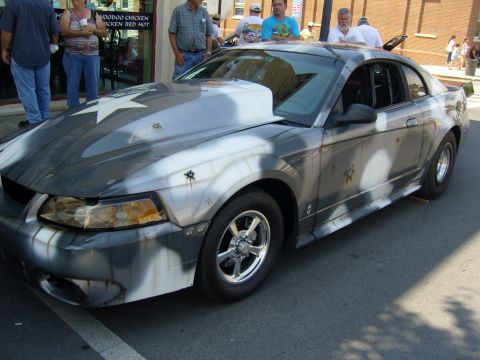 2007 Ford Mustang - A customized Ford Mustang with a unique camouflage paint job and star decals is on display.
