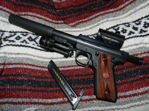 1996 Ford Bronco - Pistol with suppressor, flashlight, and red dot sight on a patterned blanket.