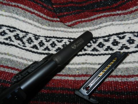 1996 Ford Bronco - A firearm with a suppressor and a loaded magazine are placed on a patterned blanket.