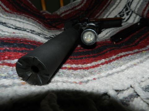 1996 Ford Bronco - A firearm with a silencer and attached flashlight rests on a colorful blanket.