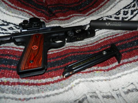 1996 Ford Bronco - A pistol is shown with a suppressor, laser, and magazine on a patterned blanket.