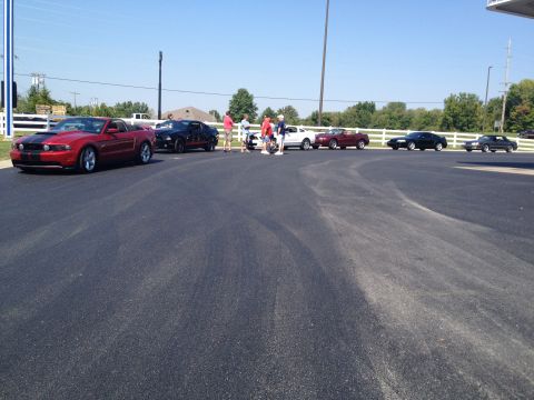 2007 Ford Mustang - Several Ford Mustangs are gathered at an outdoor event on a sunny day.