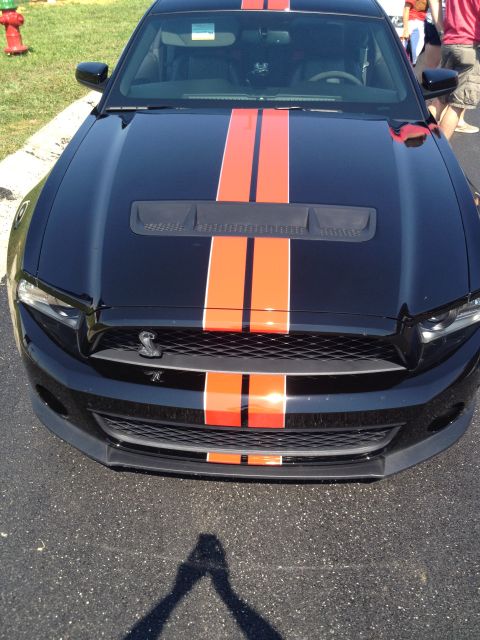 2007 Ford Mustang - A black Ford Mustang with prominent orange racing stripes is viewed from the front.