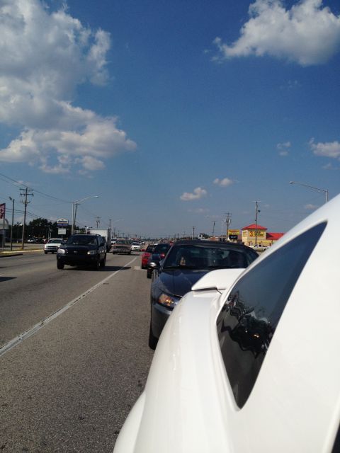 2007 Ford Mustang - A line of cars are stopped on a highway under a bright, cloudy sky.