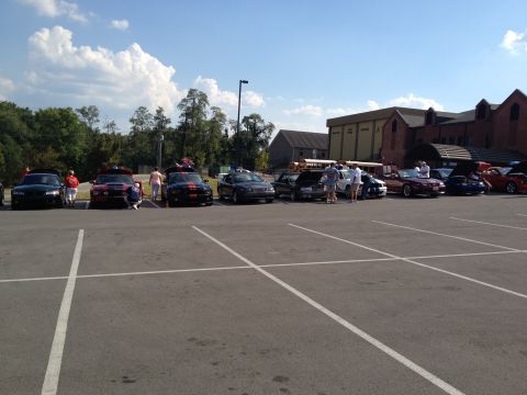 2007 Ford Mustang - Cars gathered in a parking lot on a sunny day with clouds in the sky.