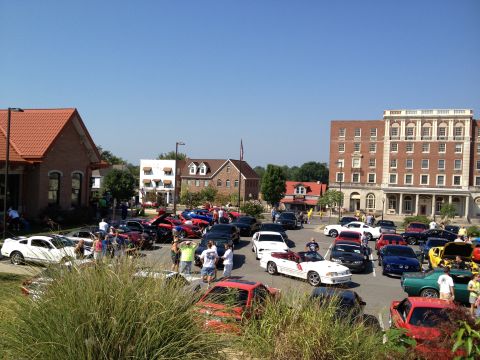 2007 Ford Mustang - A gathering of vehicles and people in a parking lot on a sunny day.