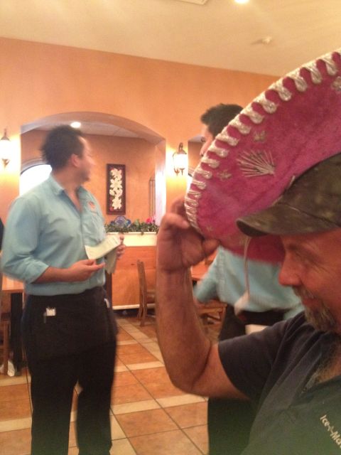 2007 Ford Mustang - A man holds a sombrero while a waiter stands by in a restaurant setting.