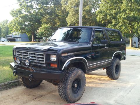 1986 Ford Bronco - This black Ford Bronco, likely from the early 1980s, is equipped with off-road enhancements.