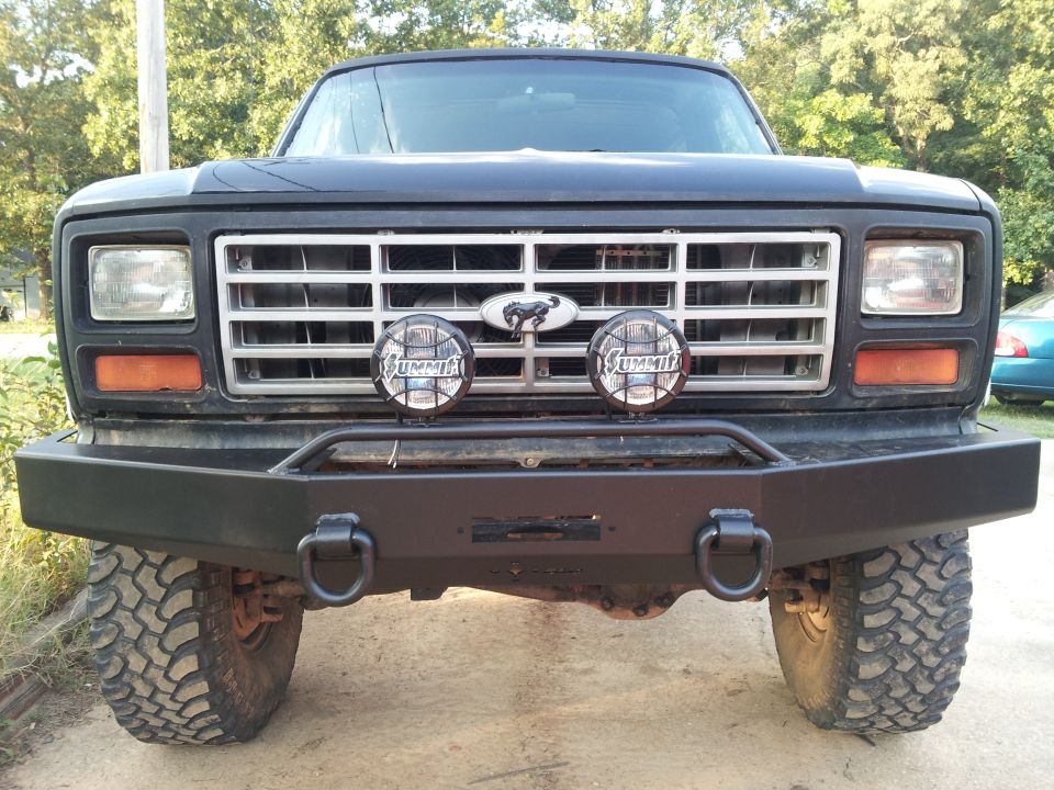 Front view of black Bronco with aftermarket bumper and Summit lights. Ford badge visible