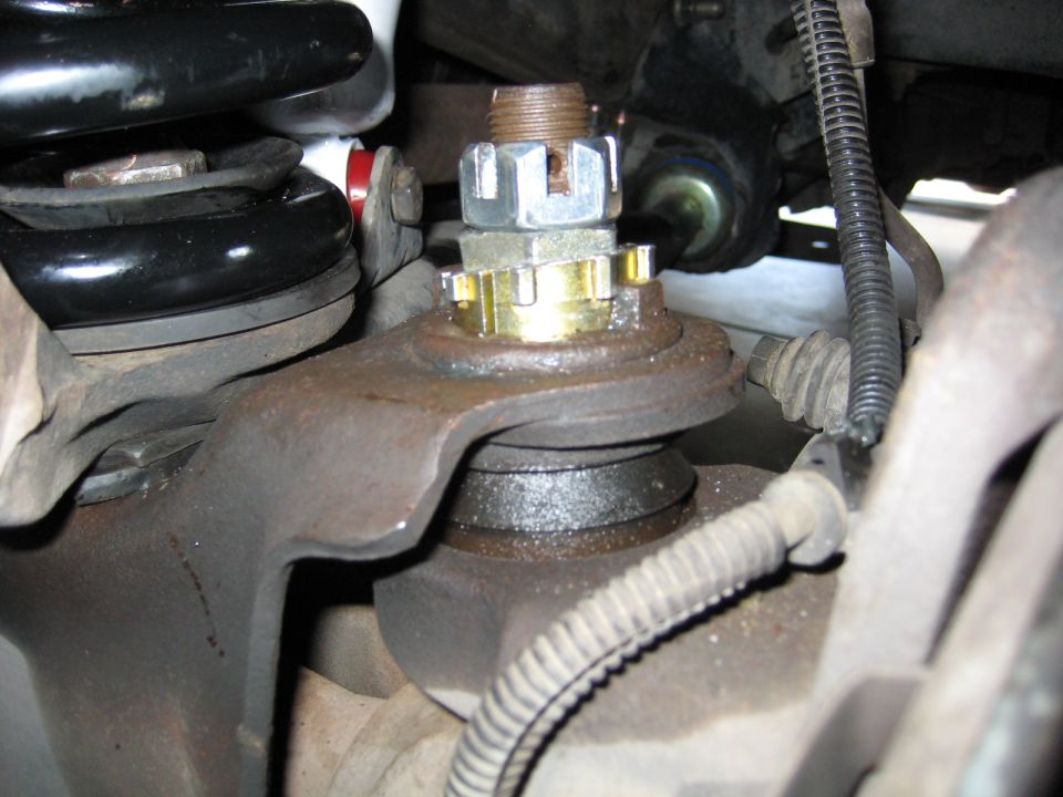 Ball joint assembly with cotter pin nut and gold washer, showing suspension components